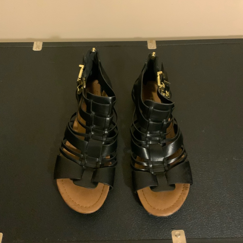 Black gladiator sandals with gold buckles